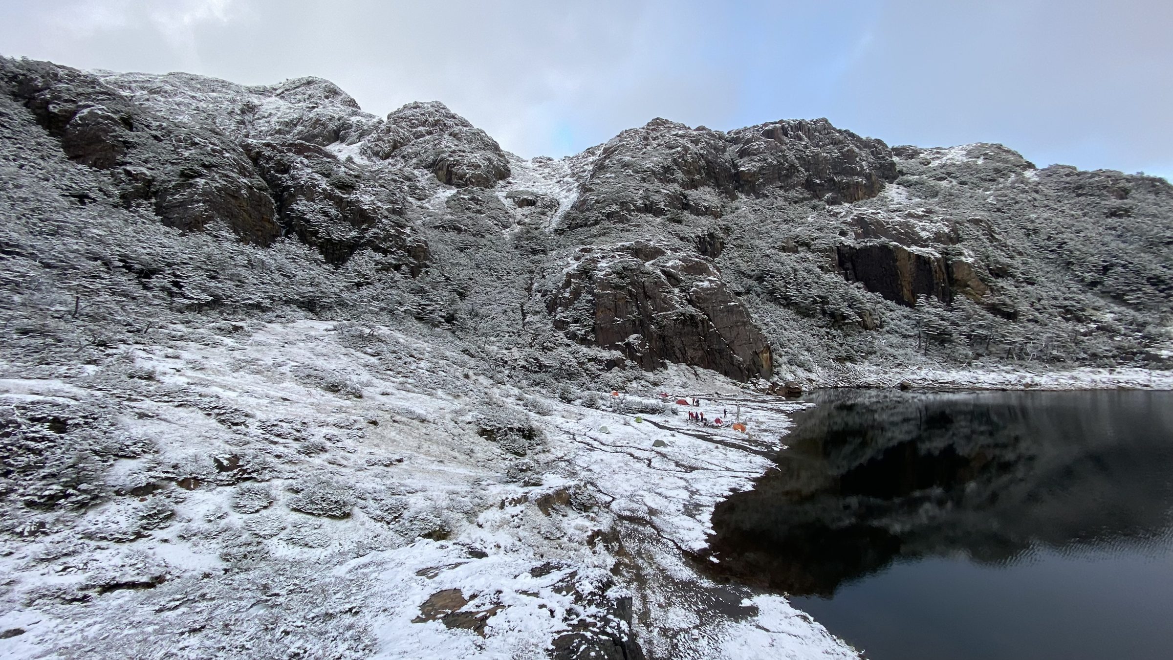 Nieve recién caída sobre una laguna de los Dientes de Navarino, bajo un cielo cerrado.