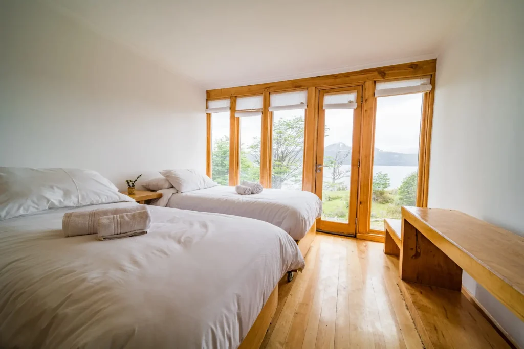 Habitación triple con dos camas y ventanal hacia el canal.