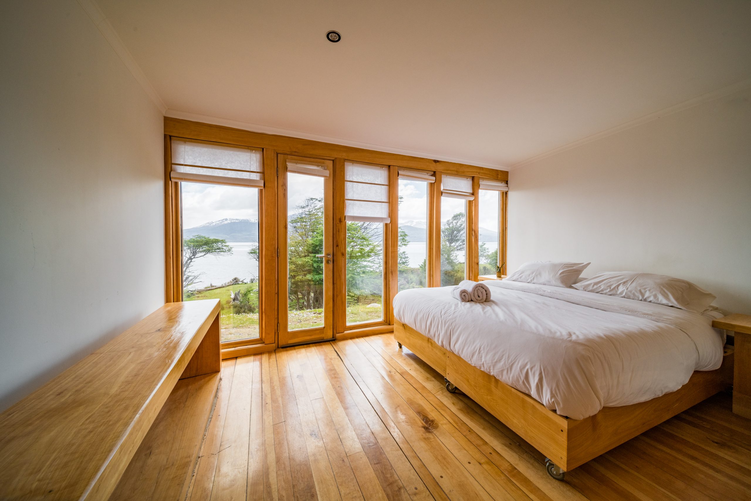 Habitación doble con cama grande frente al ventanal con vista al canal.