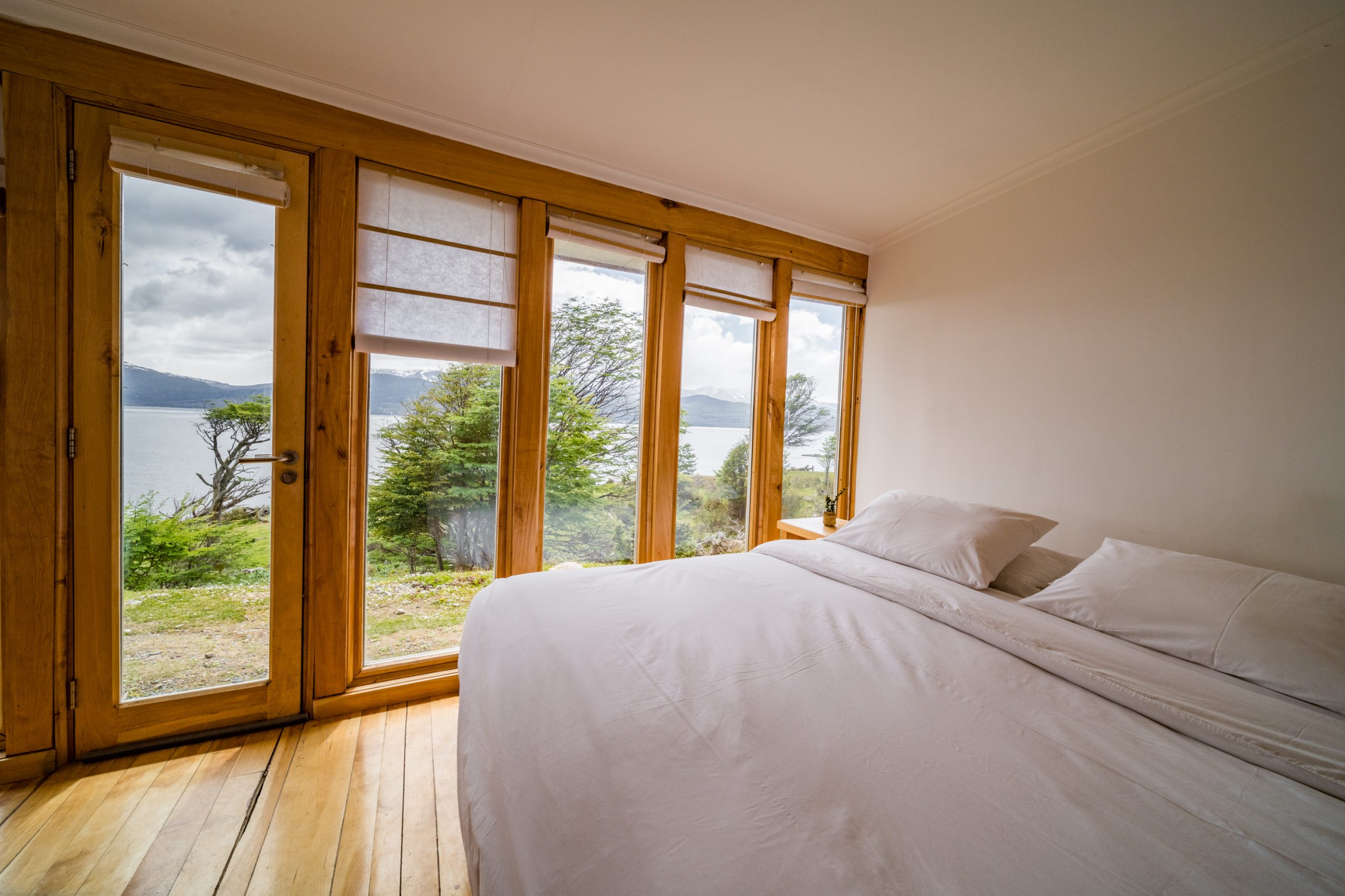 Habitación doble con cama grande y ventanal con puerta hacia el canal.
