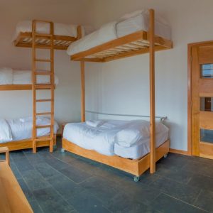 Habitación grupal con camarotes de madera de lenga para cinco personas.