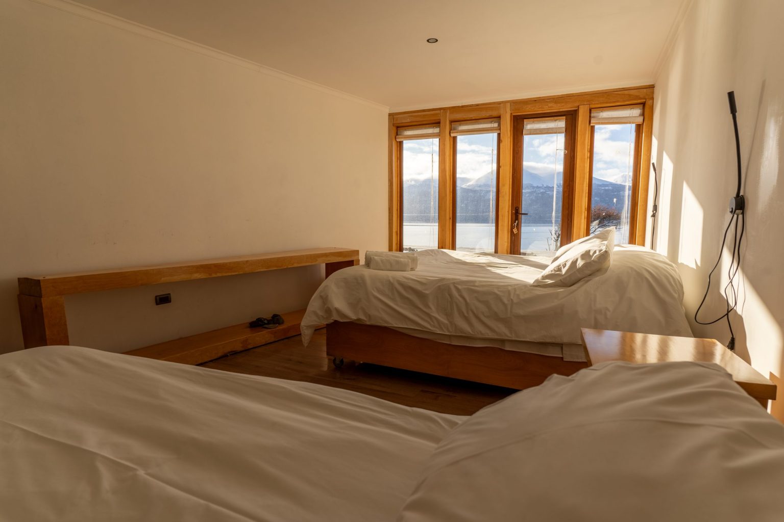 Habitación triple con dos camas frente al ventanal con vista al canal.