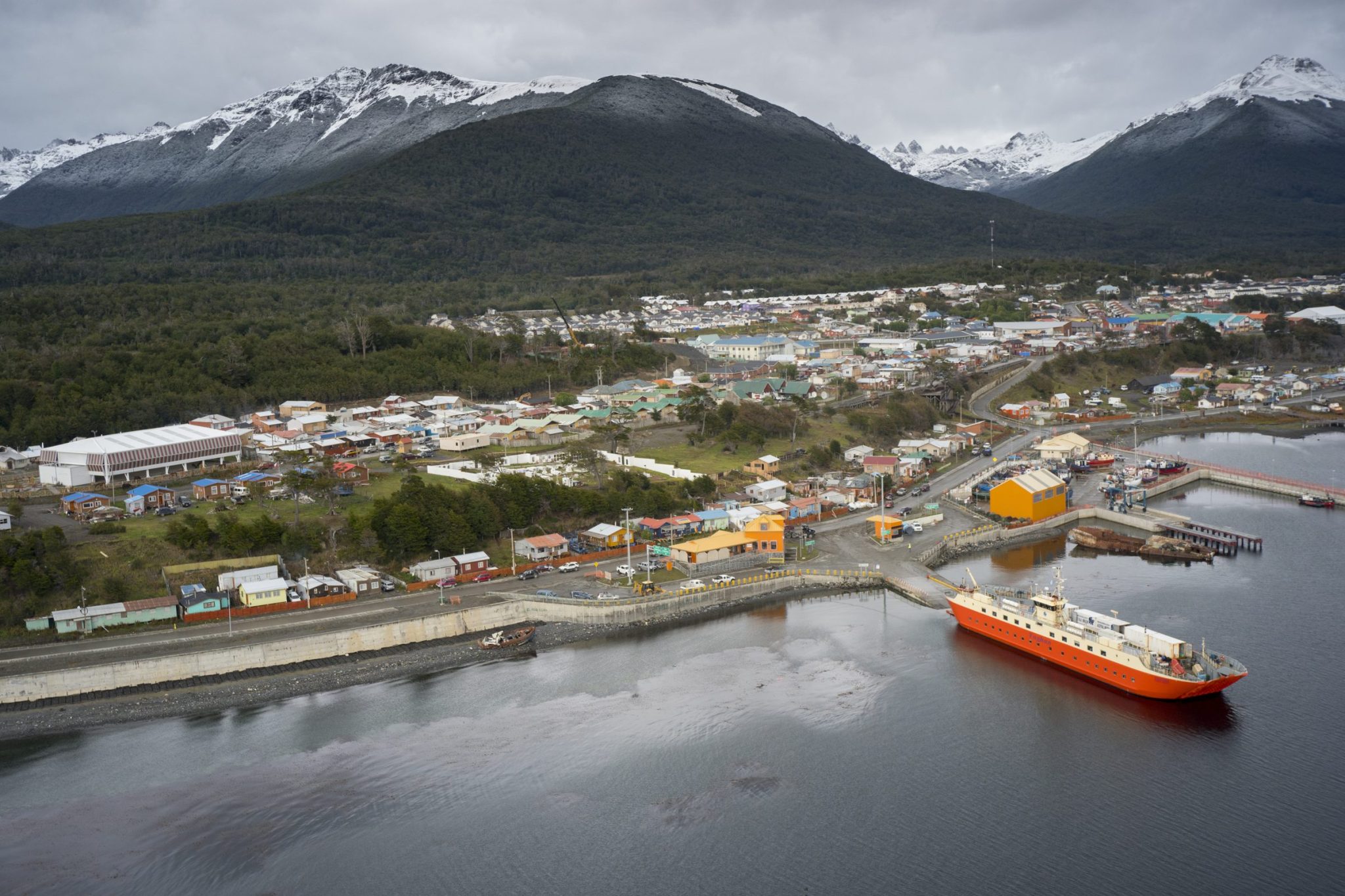 Vista aérea de Puerto Williams, con el pueblo junto a la bahía y la cordillera al fondo.